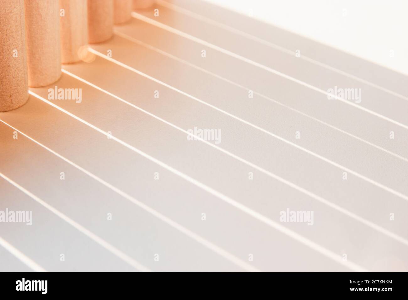 Ombre di linee rette che fanno luce una geometria su una superficie bianca con colori soleggiati. Foto Stock