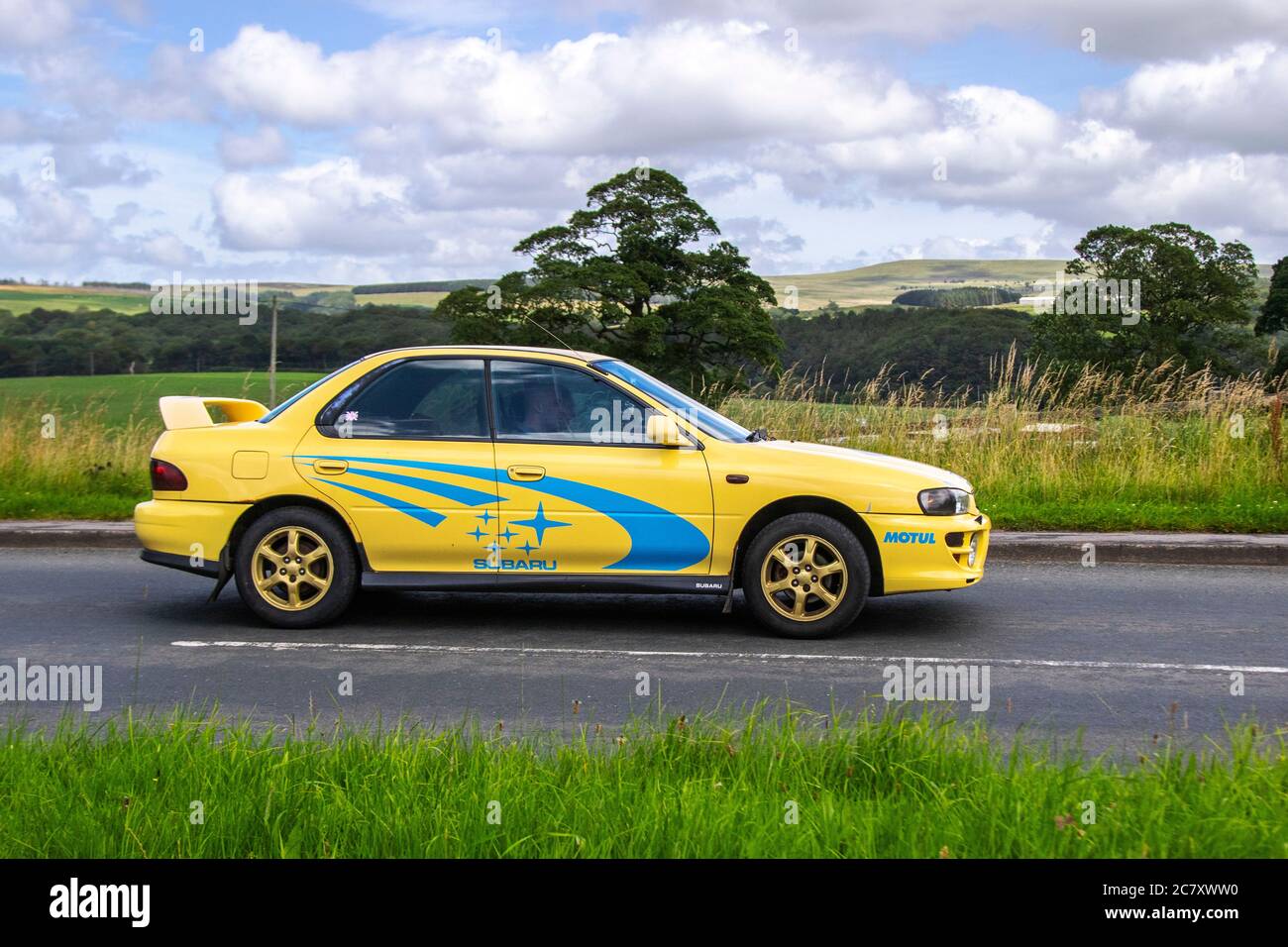 2000 blu giallo Subaru Impreza Sport Special AWD; veicoli in movimento per il traffico veicolare, automobili che guidano veicoli su strade britanniche, motori, motori sulla rete autostradale M6. Foto Stock