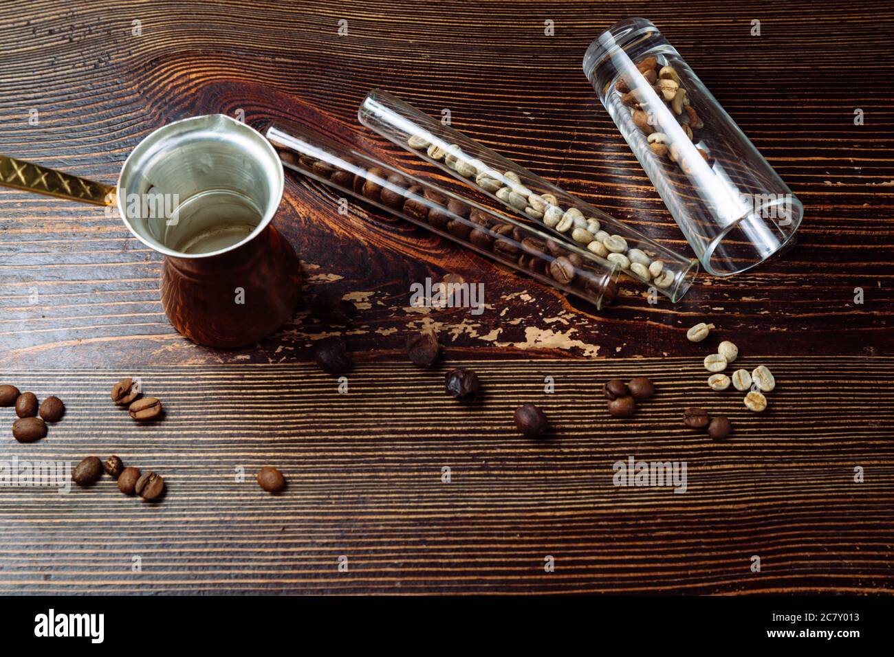 Cezve di caffè e chicchi di caffè su sfondo di legno. Foto Stock