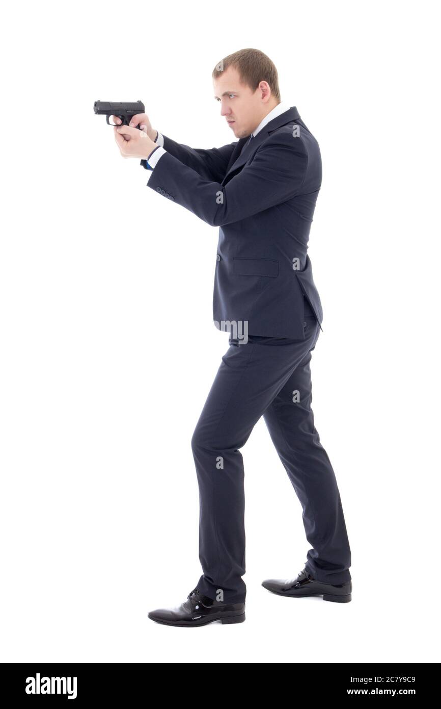 agente segreto uomo in abito da lavoro in posa con pistola isolato su sfondo bianco Foto Stock