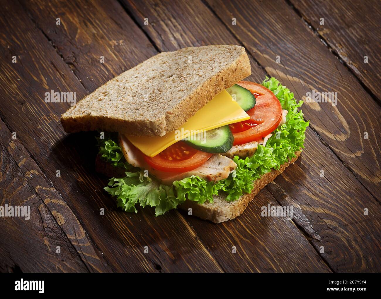 panino con pancetta con pomodori freschi, foglie di insalata di lattuga, cetriolo e formaggio, su sfondo rustico di legno tabella, nessuno Foto Stock