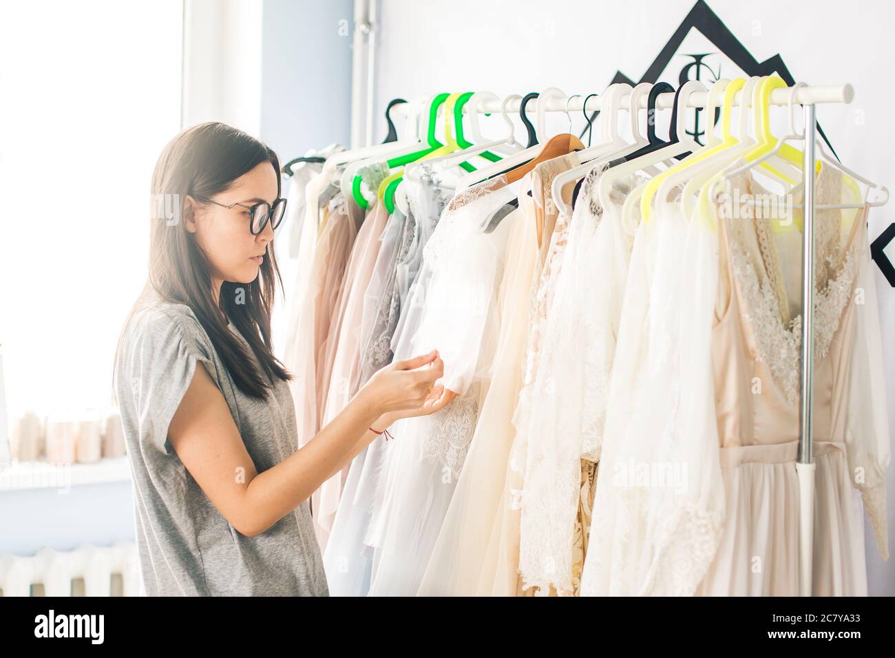 Un ritratto di una giovane stilista di moda o di un lavoro su misura su un disegno o una bozza, lei fa un piccolo adattamento al suo lavoro Foto Stock