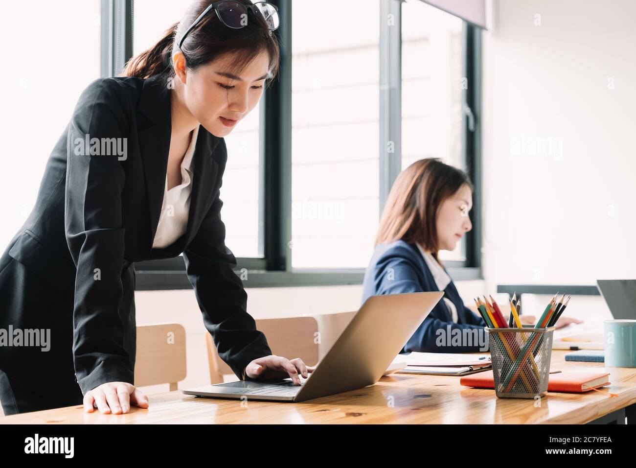 Donna d'affari asiatica che lavora con un computer portatile per le imprese analizza nella sala riunioni Foto Stock