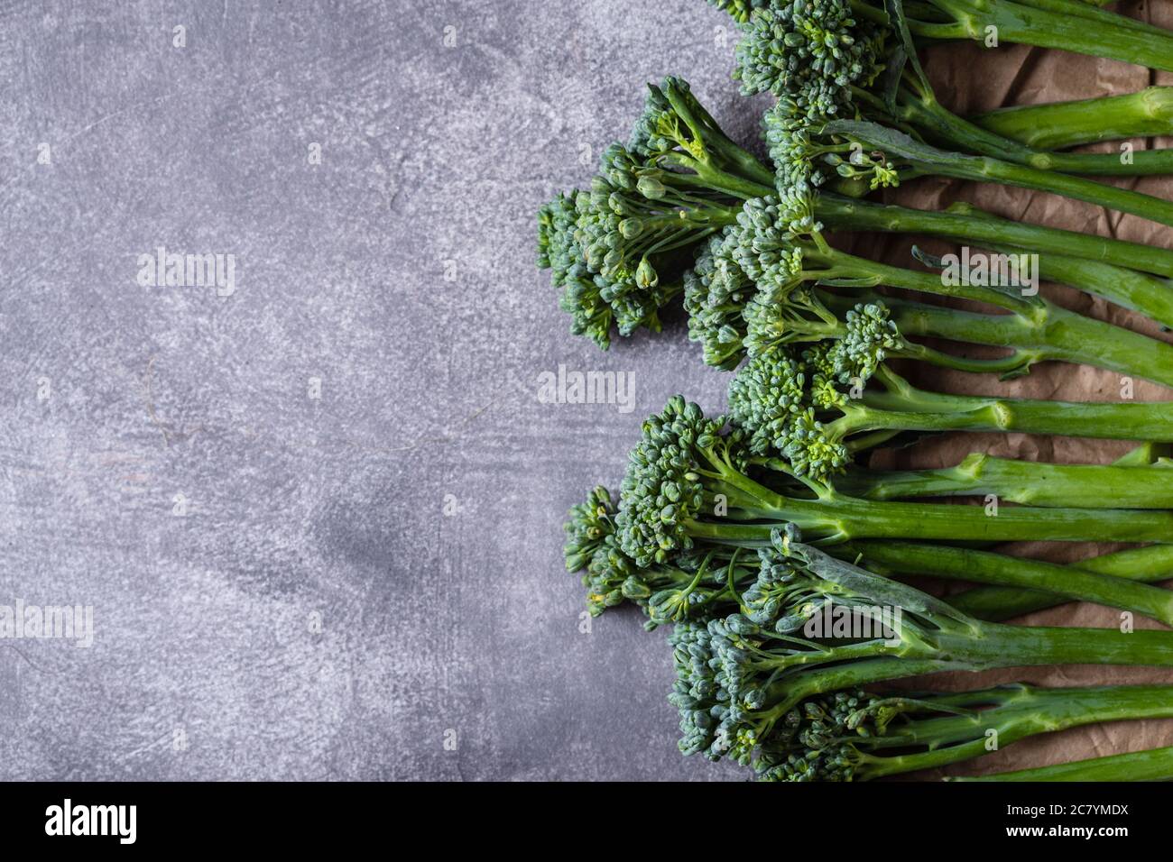 Bordo di broccolini su fondo grigio in pietra. Vista dall'alto con spazio per la copia. Foto Stock