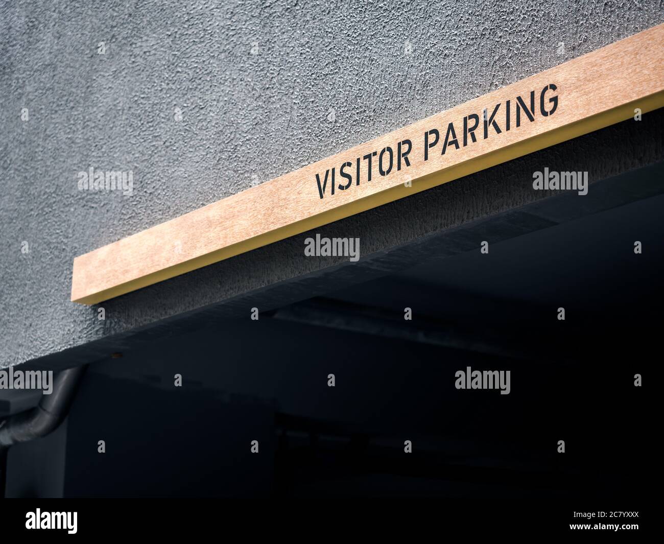 Cartello per il parcheggio per i visitatori. Parcheggio in legno segno sopra il parcheggio in appartamento moderno con spazio per fotocopie. Foto Stock