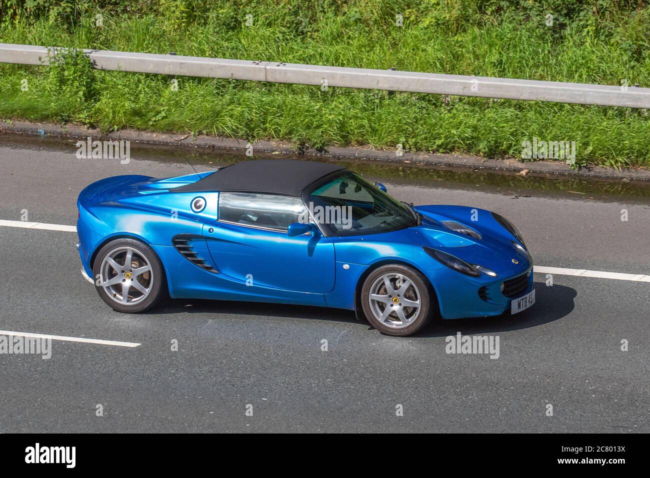 2011 Blue Lotus Elise Car Roadster benzina da 1794 cc, due posti, trazione posteriore, roadster a motore medio; veicoli in movimento per traffico veicolare, automobili che guidano su strade del Regno Unito, motori, motori sulla rete autostradale M6. Foto Stock