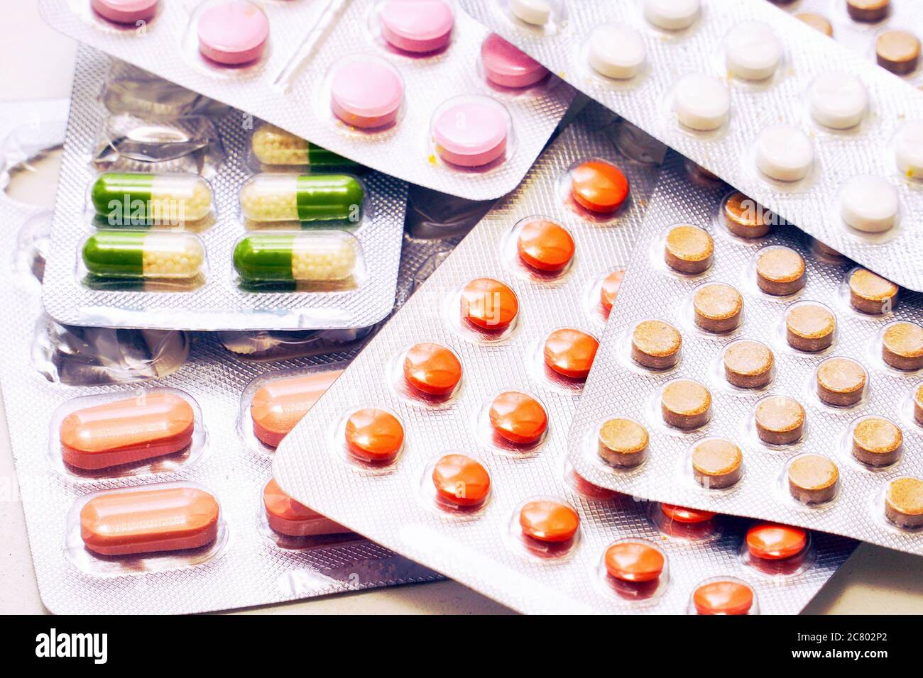 Compresse e capsule di diversi colori confezionate in blister. Informazioni farmaceutiche o mediche Foto Stock