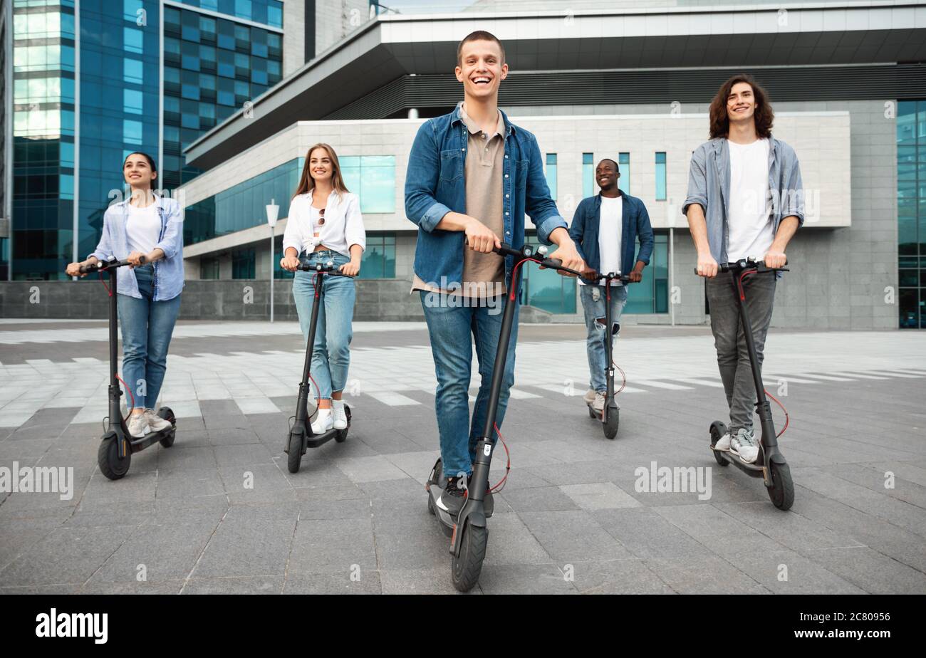 Cinque amici che cavalcano su scooter motorizzati Foto Stock