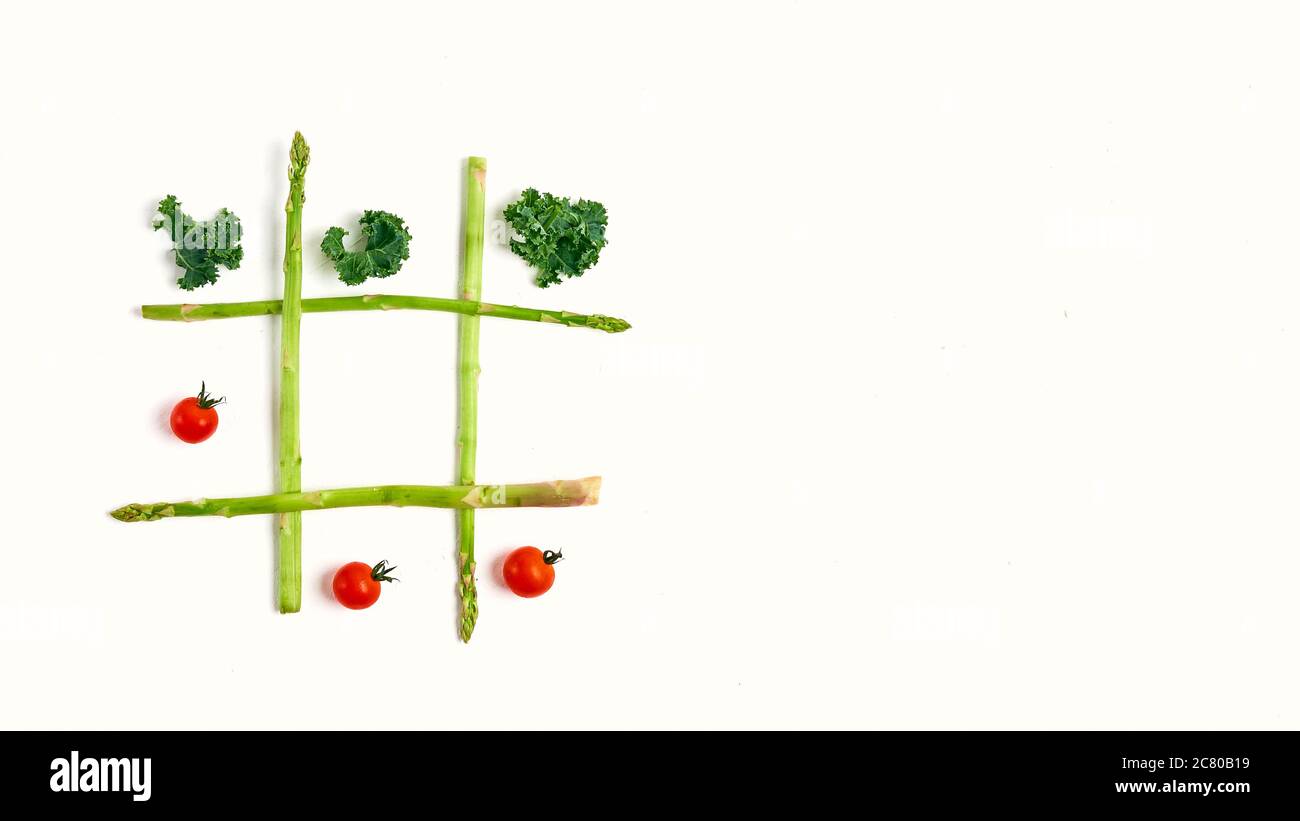 Tic Tac Toe con il cibo, gli asparagi kale, il pomodoro, il concetto di dimagrimento, decisione, scelta la vittoria Foto Stock