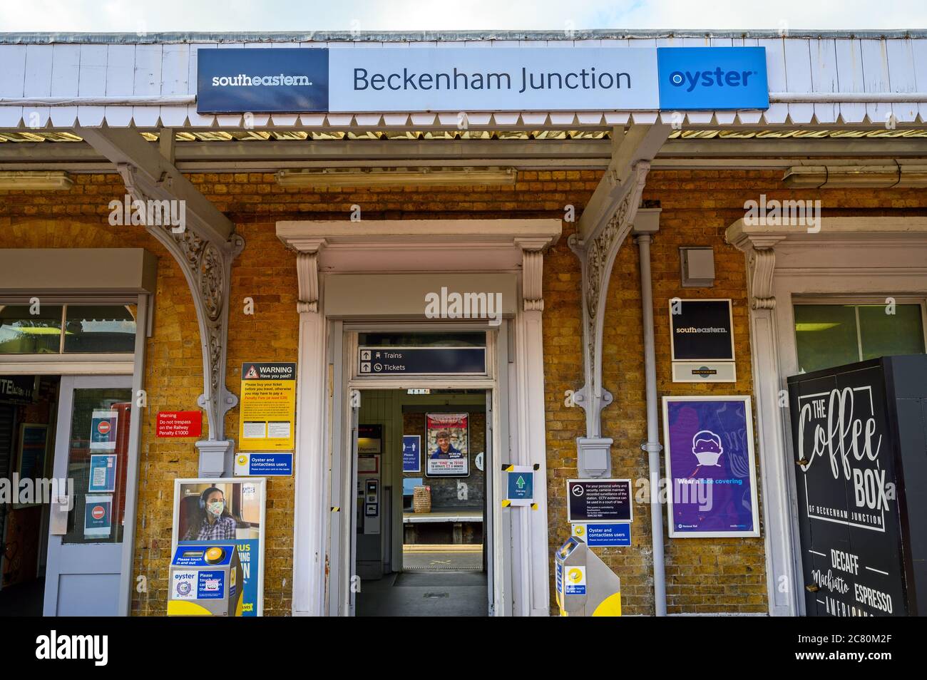 Beckenham (Greater London), Kent, Regno Unito. Ingresso alla stazione ferroviaria di Beckenham Junction con cartello della stazione e lettori di carte che guardano attraverso la piattaforma. Foto Stock