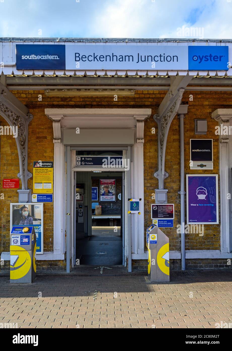 Beckenham (Greater London), Kent, Regno Unito. Ingresso alla stazione ferroviaria di Beckenham Junction con cartello della stazione e lettori di carte che guardano attraverso la piattaforma. Foto Stock