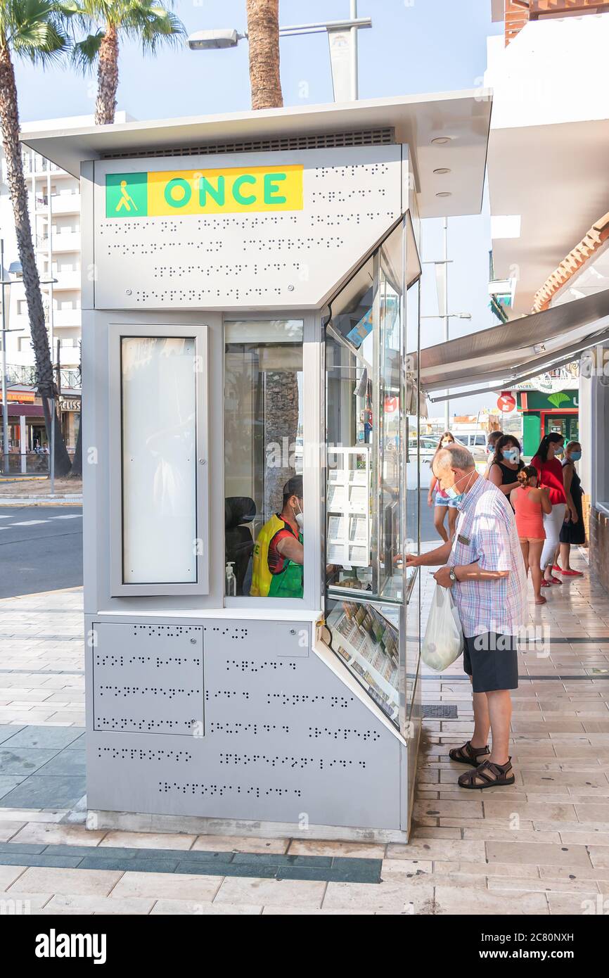 Punta Umbria, Huelva, Spagna - 11 luglio 2020: L'uomo in maschera protettiva sta acquistando biglietti per lotteria in un chiosco A Punta Umbria, Andalusia, Spagna Foto Stock