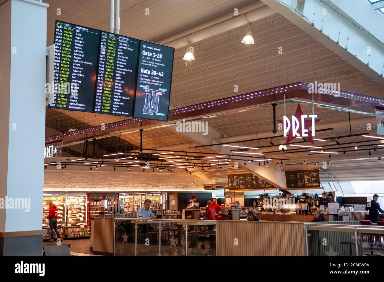 Il Pret A Manager, il ristorante internazionale con sandwich e in primo piano una mostra di partenza nella sala partenze dell'aeroporto di Stansted. Foto Stock