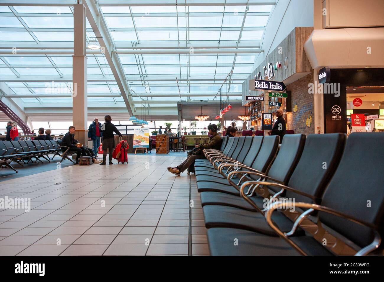 La Bella Italia, colazione e pizzeria con persone sedute nell'area pubblica in primo piano dell'aeroporto di Stansted nella sala partenze. Foto Stock