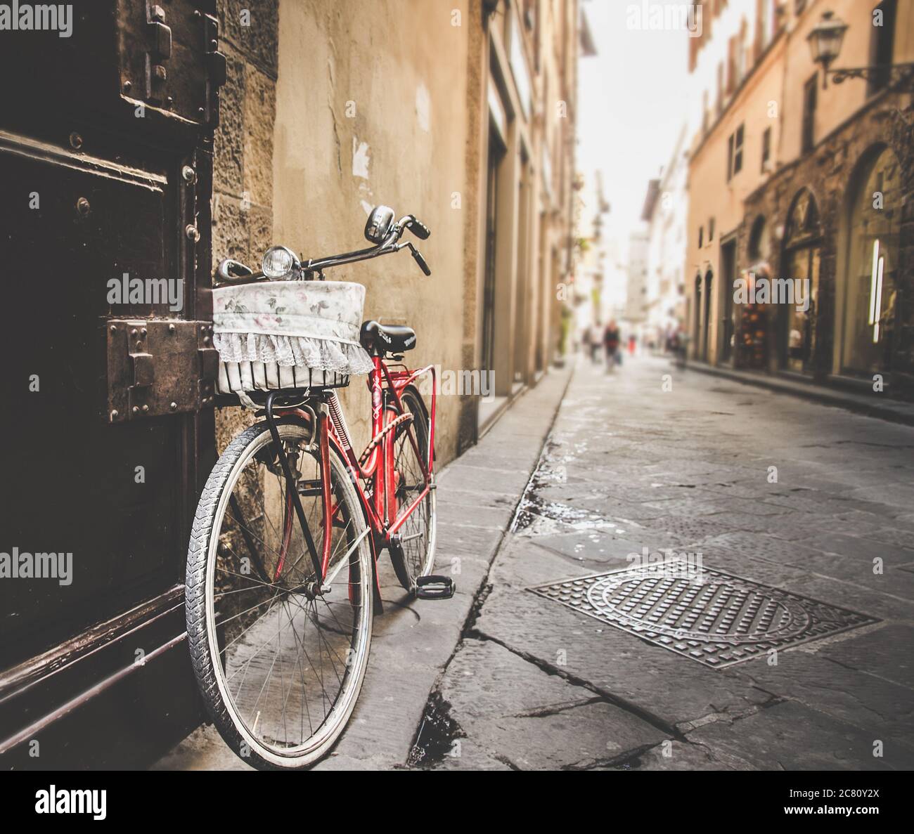 Fuoco selettivo di una bicicletta rossa in una strada A Firenze catturato durante il giorno Foto Stock