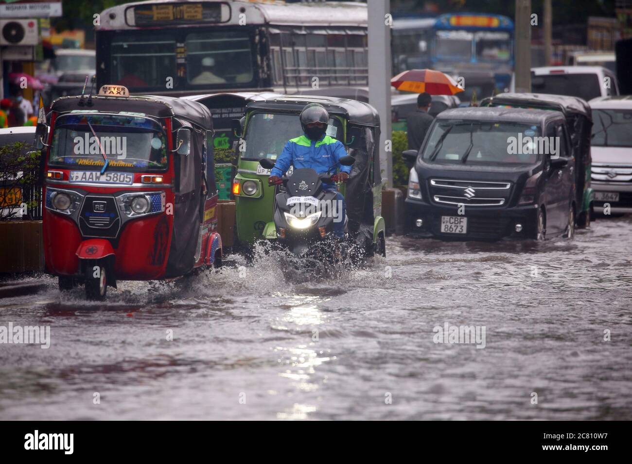 Colombo, Sri Lanka. 20 luglio 2020. I veicoli attraversano una strada sommerso a Colombo, Sri Lanka, 20 luglio 2020. Il Dipartimento di Meteorologia dello Sri Lanka e l'Organizzazione Nazionale per la Ricerca sull'Edilizia (NBRO) di lunedì hanno emesso un avvertimento rosso per le piogge intense e le frane nei prossimi giorni in diversi distretti del paese e hanno esortato migliaia di residenti ad adottare misure precauzionali. Gli avvertimenti sono stati emessi per la capitale Colombo, Kalutara alla periferia della capitale e Kegalle e Ratnapura nel centro-sud dello Sri Lanka. Credit: Ajith Perera/Xinhua/Alamy Live News Foto Stock