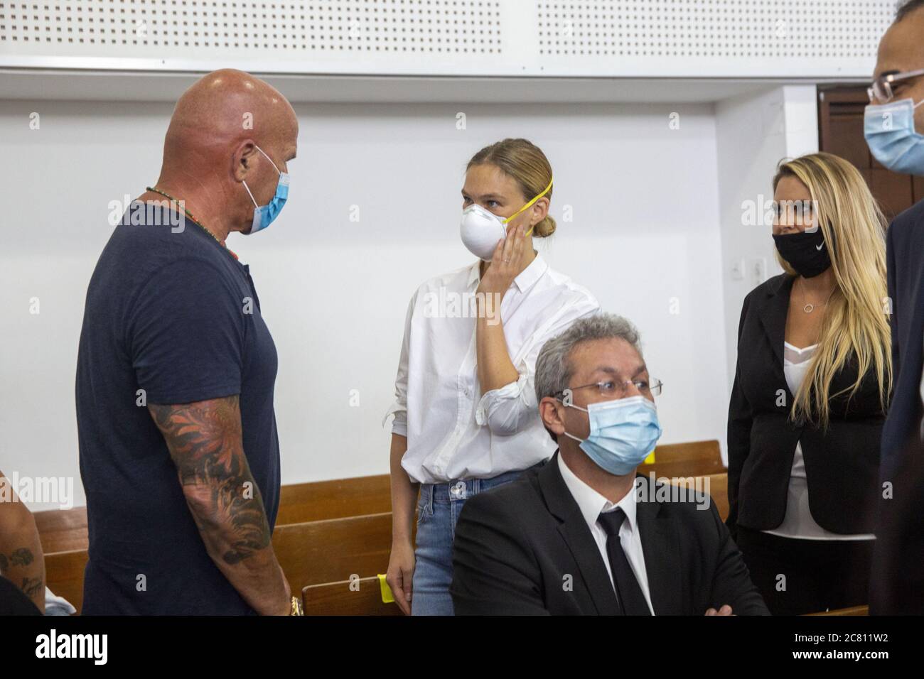 Tel Aviv, Israele. 20 luglio 2020. Il primo modello israeliano Bar Refaeli, centro, con una maschera arriva in tribunale insieme al padre Raffi, a sinistra, e gli avvocati, a Tel Aviv, Israele, lunedì 20 luglio 2020. Refaeli ha firmato un accordo di contrattazione con le autorità per risolvere un caso di evasione fiscale di lunga data contro lei e la sua famiglia. L'accordo richiederà a Refaeli di servire nove mesi di servizio comunitario, mentre sua madre, Zipi, sarà inviata in carcere per 16 mesi. Foto di piscina di Oded Balilty/UPI Credit: UPI/Alamy Live News Foto Stock