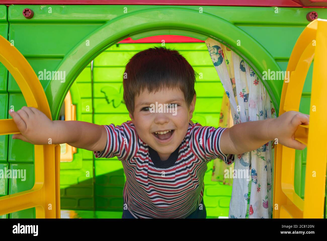 Un bambino di 3 anni in una T-shirt a righe apre una finestra, gioca in una  casa giocattolo in un centro per bambini. Zona giochi, sviluppo bambini  Foto stock - Alamy