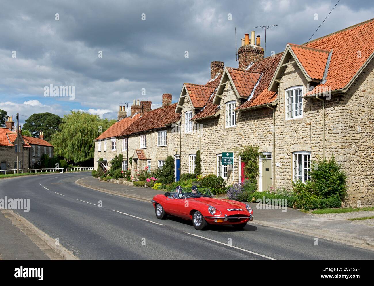 Auto sportiva Red e-TYPE Jaguar nel villaggio di Hovingham, Ryedale, North Yorkshire, Inghilterra UK Foto Stock