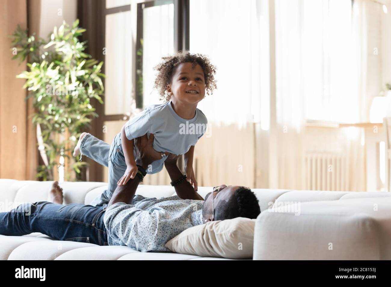 Amore papà afroamericano giocare con il figlio piccolo Foto Stock