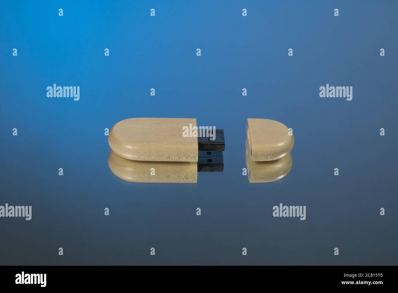 bastoni usb con cappuccio aperto in bambù e boscaiolo. Sfondo speculare. Sfondo blu Foto Stock