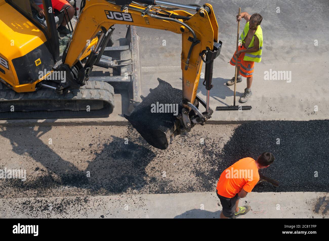 addetti alla manutenzione stradale e escavatore Foto Stock