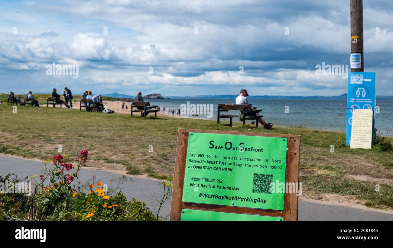 North Berwick, East Lothian, Scozia, Regno Unito, 20 luglio 2020. Campagna contro il piano di parcheggio di Covid-19: East Lothian Council propone un parcheggio temporaneo per 200 lunghi soggiorni sul famoso Elcho Green, West Beach; parte di 'passi per le persone' per aiutare le persone a distanza sociale durante la pandemia di coronavirus & per compensare i commercianti per la perdita di parcheggio già rimosso in High Street. Una petizione online 'West Bay Not a Parking Bay' per opporsi alla distruzione del luogo di bellezza ha raccolto quasi 4,000 firme.UN avviso invita le persone a firmare la petizione legge Salva il nostro Seafront (SOS) Foto Stock