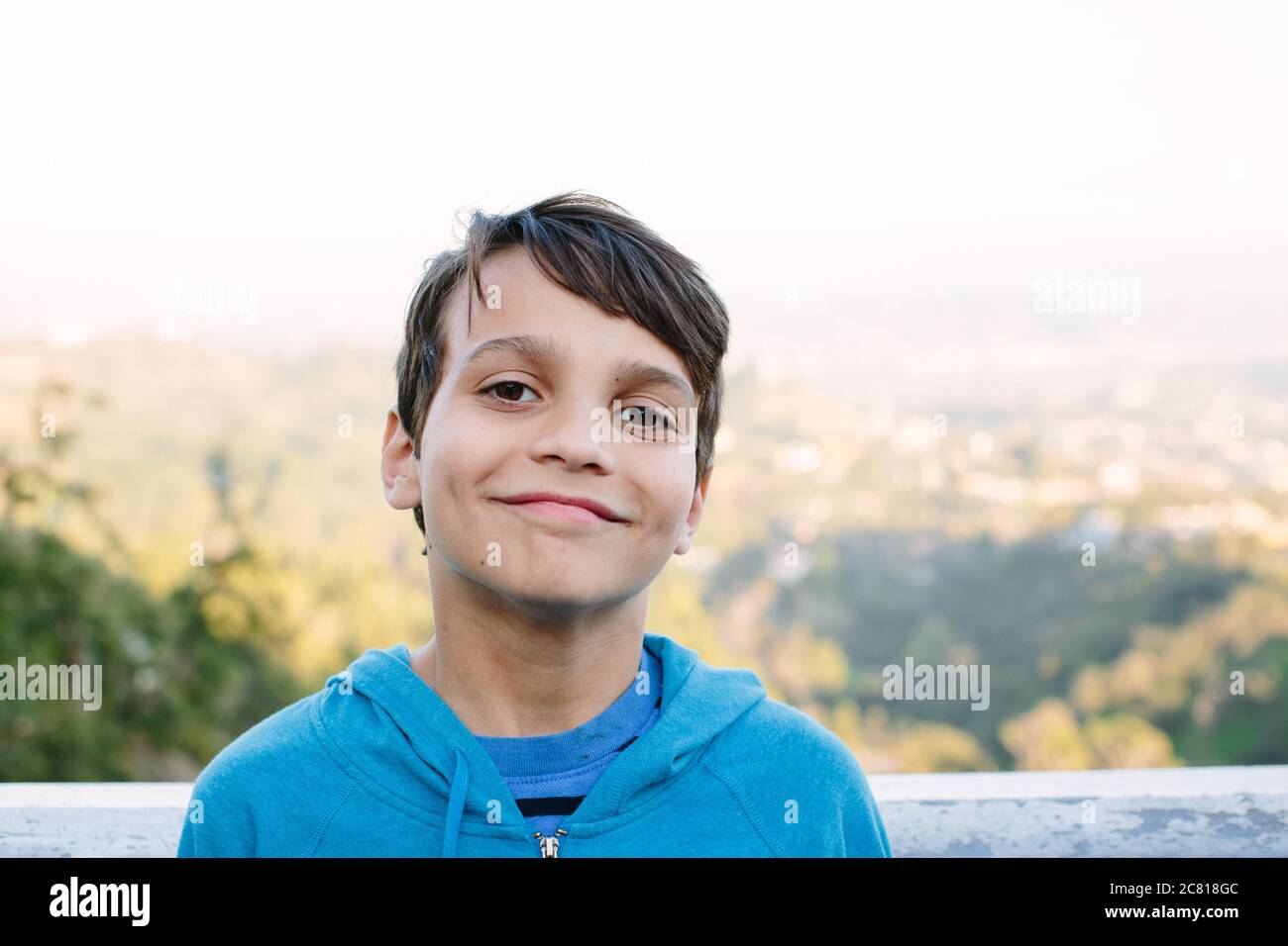 Sorridente ragazzo di dieci anni sabbie di fronte a un Vista su LOS ANGELES Foto Stock