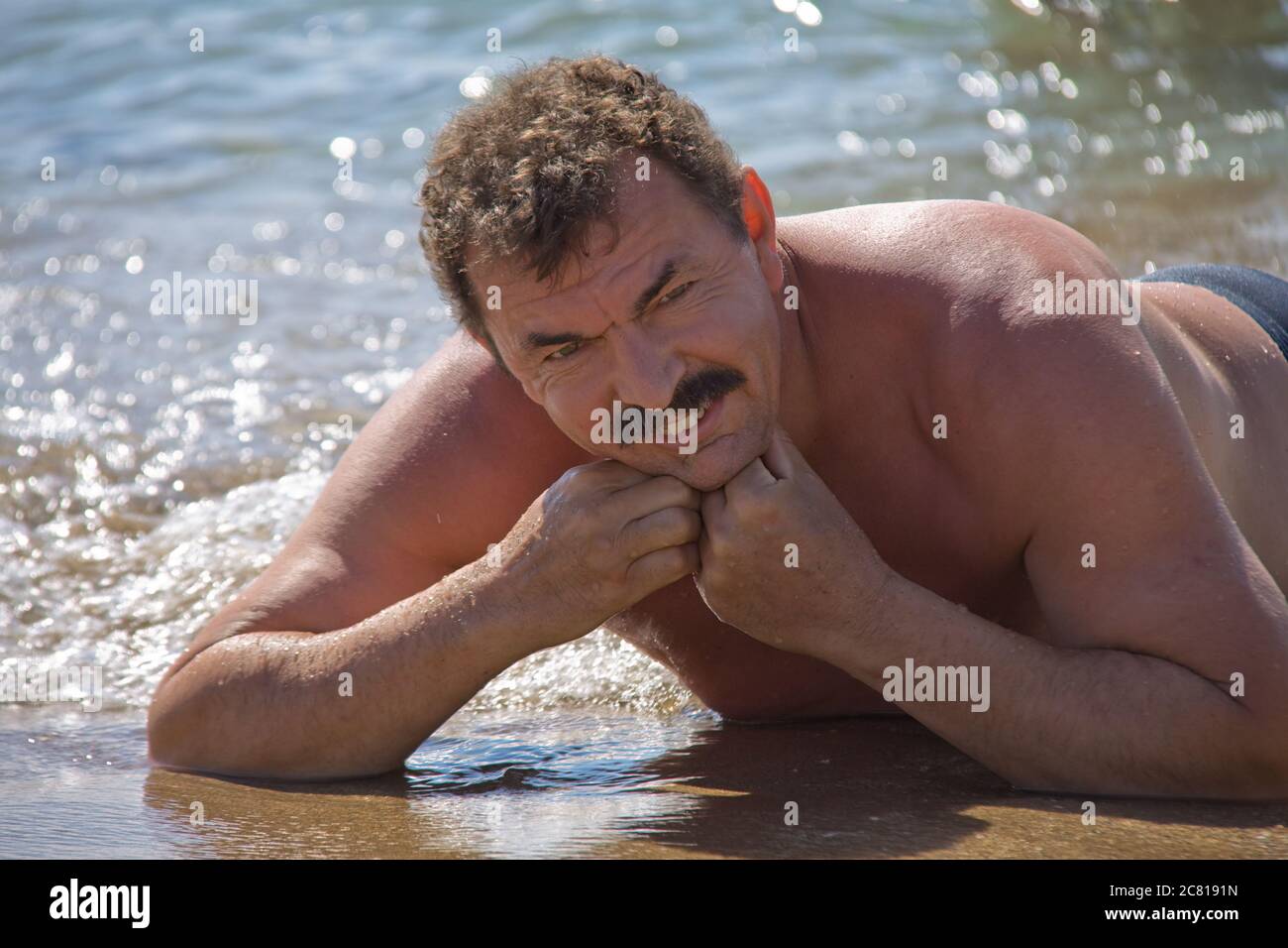 L'uomo si sdraia sulla sabbia Foto Stock