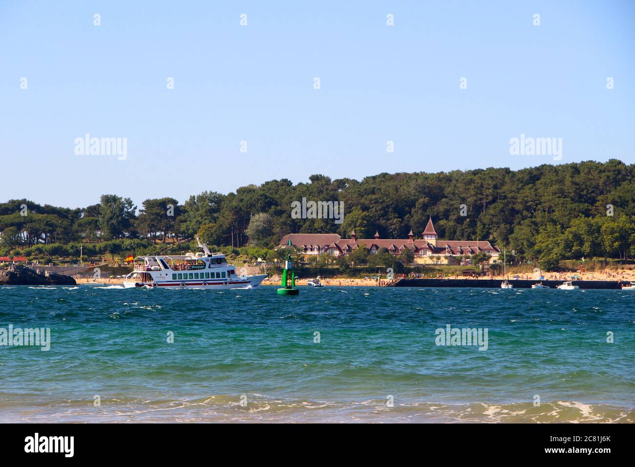 Battello da diporto che passa di fronte al campo estivo di Menéndez Pelayo International University UIMP nei terreni del Palazzo Magdalena Santander Foto Stock