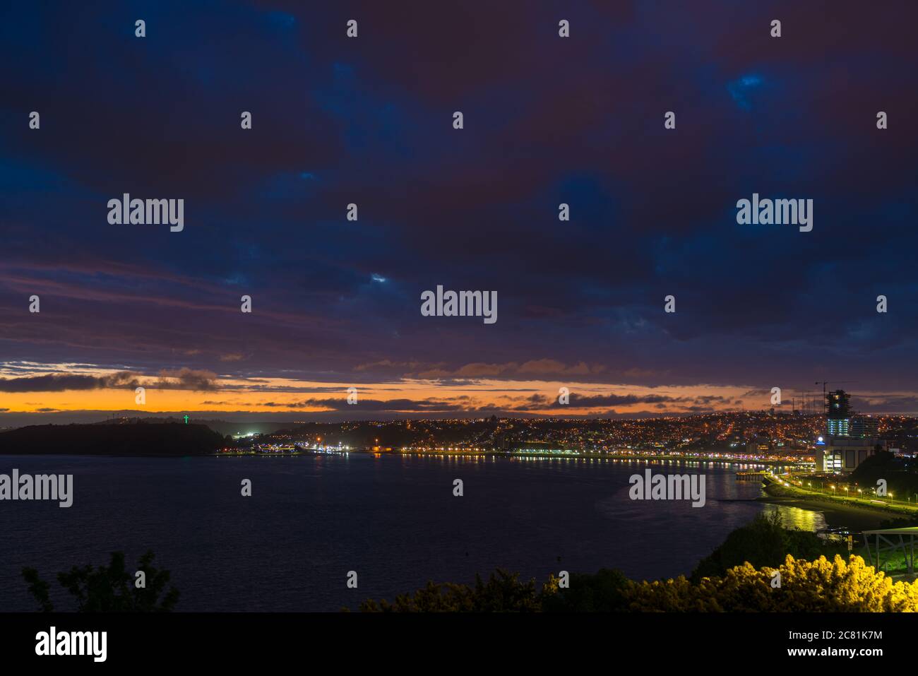Baia di Puerto Montt e luci della città dopo il tramonto, cielo nuvoloso Foto Stock