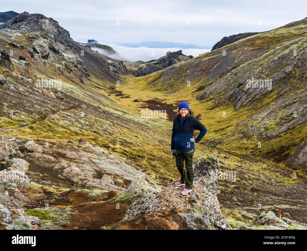 Una donna si trova sul terreno accidentato dell'Islanda meridionale; Grimsnes- og Grafningshreppur, regione meridionale, Islanda Foto Stock