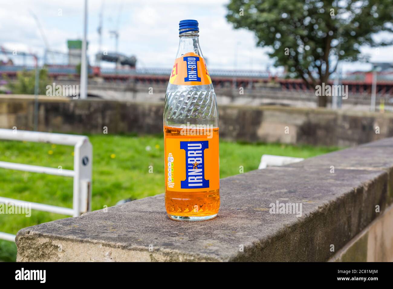Una mezza bottiglia piena di Barr's Irn Bru scartata su una strada cittadina, Glasgow, Scozia, Regno Unito Foto Stock