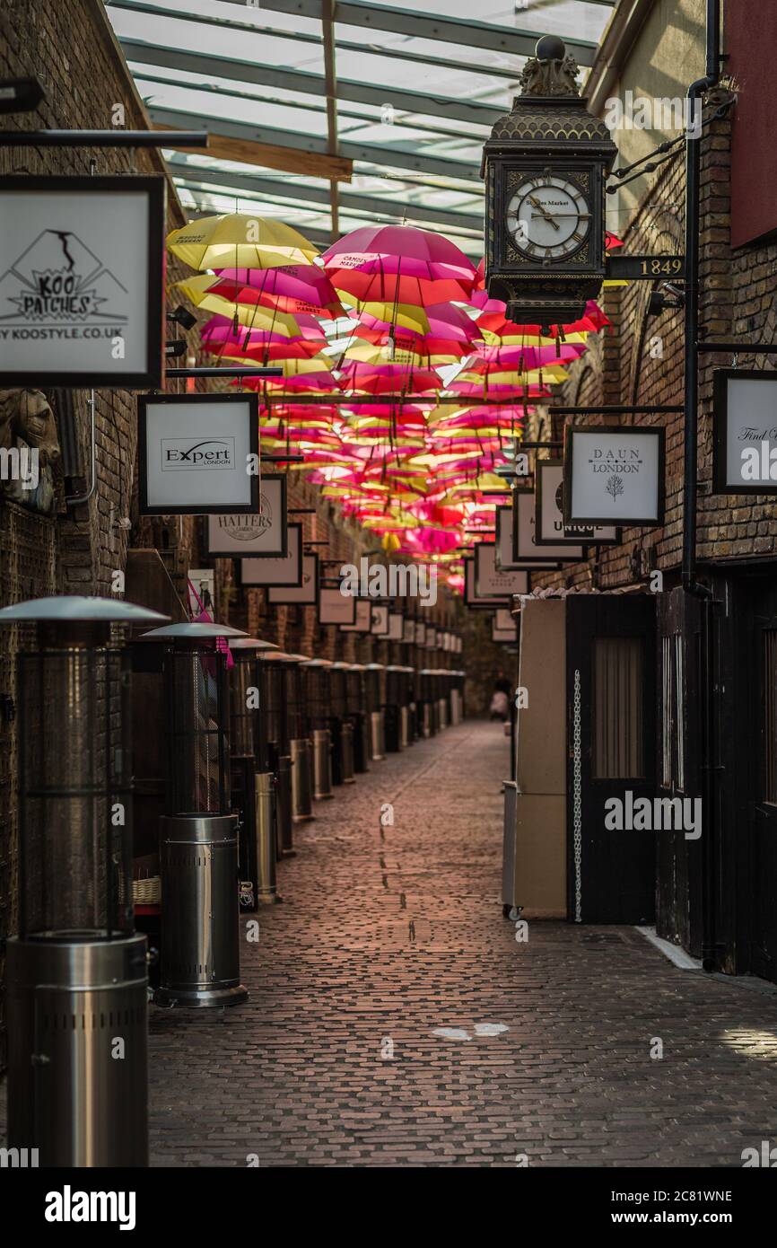 Colorato vicolo di ombrelli appesi nelle famose Camden Stables di Londra. Foto Stock