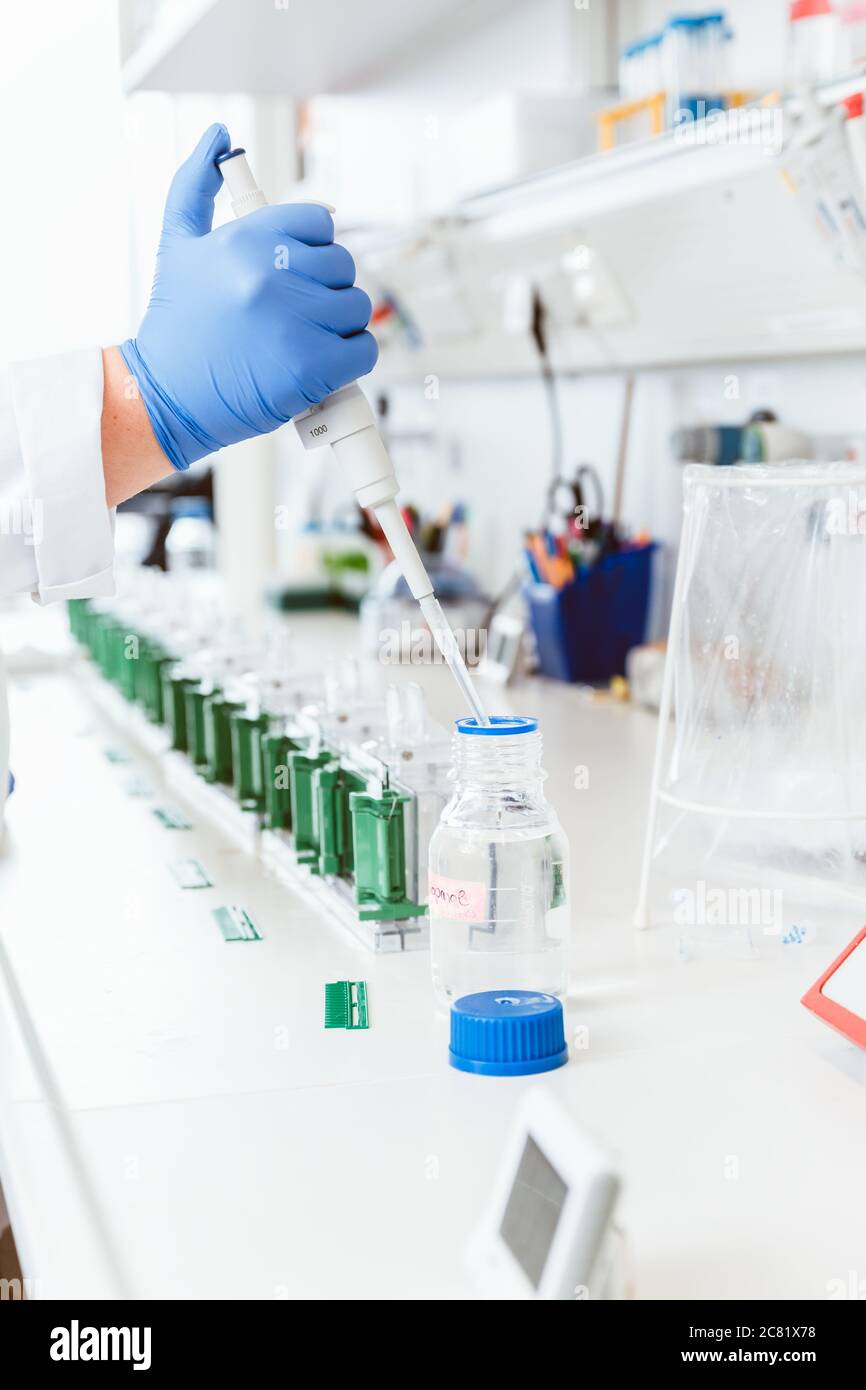 Rimozione di liquidi da parte di scienziati per il campionamento Foto Stock