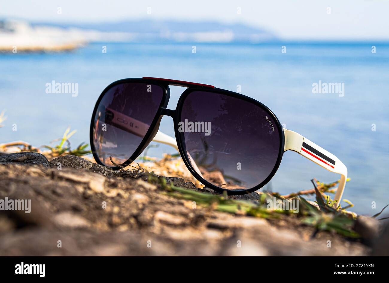 Bella vacanza estiva. Gli occhiali da sole sono sdraiati sulla spiaggia, in estate, con il sole, contro il mare della città di Gelendzhik Foto Stock