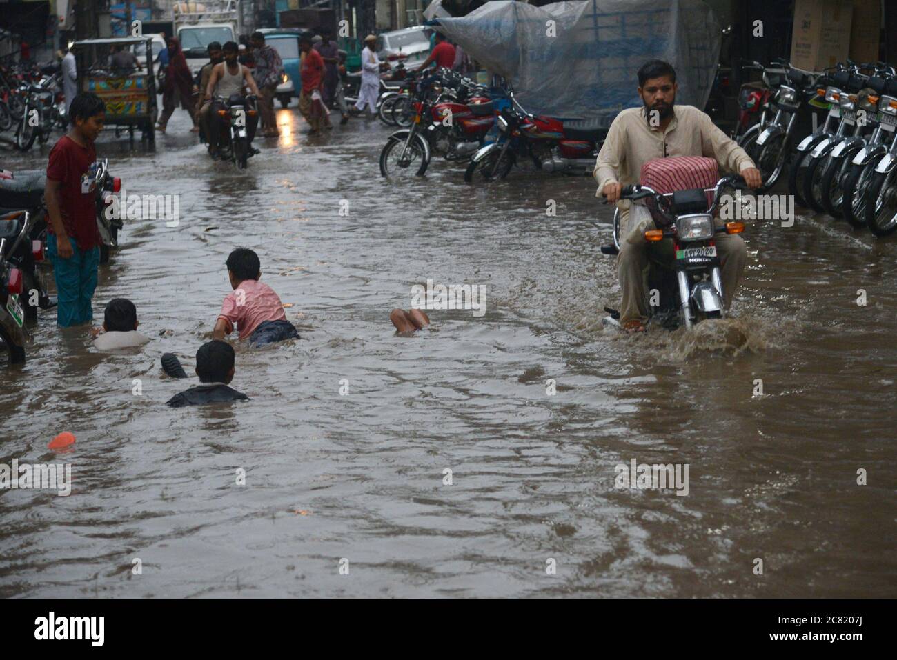 Lahore, Pakistan. 20 luglio 2020. I pendolari pakistani si sono guastati attraverso una strada allagata dopo un pesante incantesimo di pioggia monsone nella capitale provinciale di Lahore, Pakistan, il 20 luglio 2020. (Foto di Rana Sajid Hussain/Pacific Press/Sipa USA) Credit: Sipa USA/Alamy Live News Foto Stock