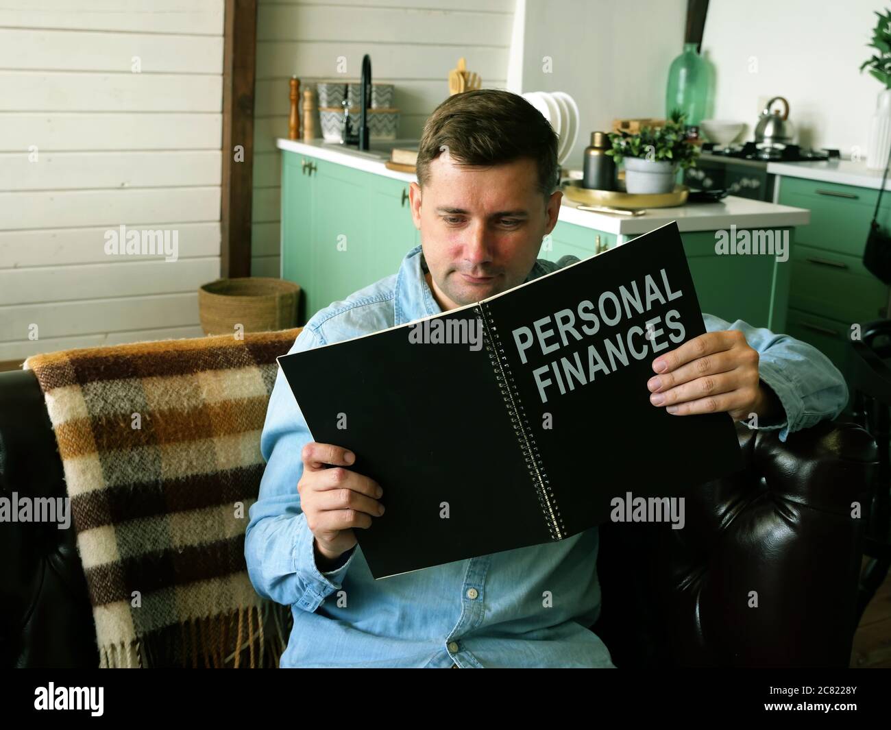 L'uomo legge sulle finanze personali. Concetto di alfabetizzazione finanziaria. Foto Stock