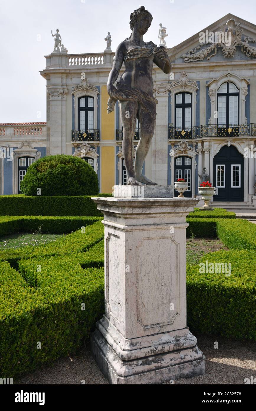 Queluz, Portogallo - 3 giugno 2017: Giardini di Nettuno, scultura la Primavera dello scultore John Cheere e le facciate del Palazzo reale di Queluz Foto Stock