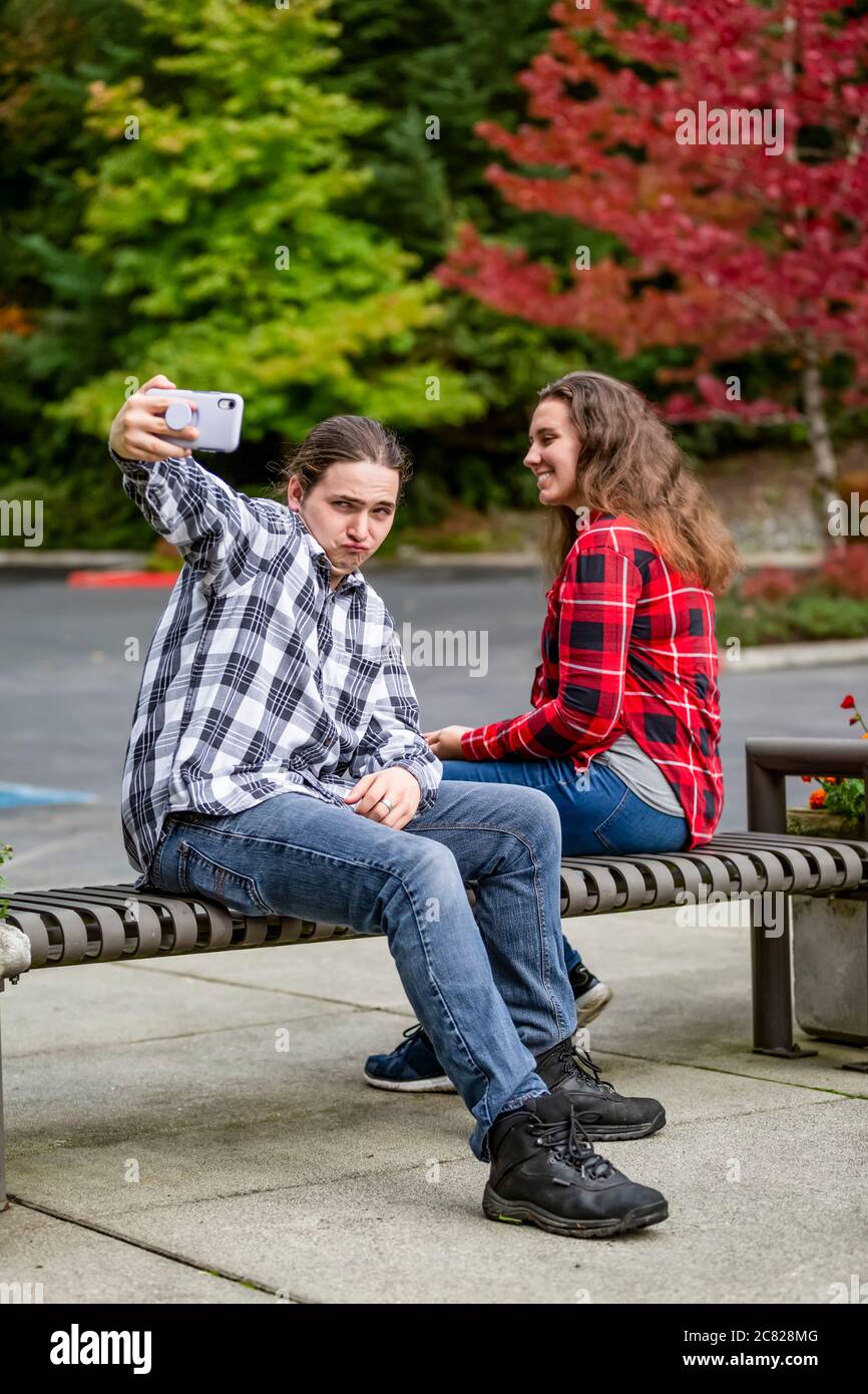 Una giovane coppia prendendo un autoritratto con uno smart phone; Bothell, Washington, Stati Uniti d'America Foto Stock