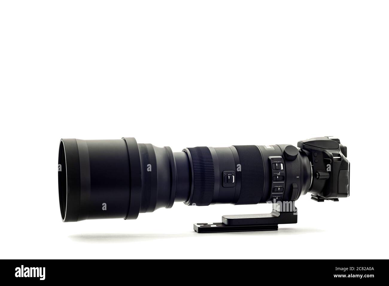 Scatto orizzontale di una moderna fotocamera reflex digitale con super teleobiettivo zoom su sfondo bianco. Foto Stock