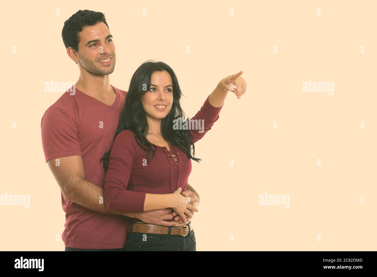 Considerato giovane coppia felice sorridere mentre abbraccia ogni altro con la donna rivolta a distanza Foto Stock