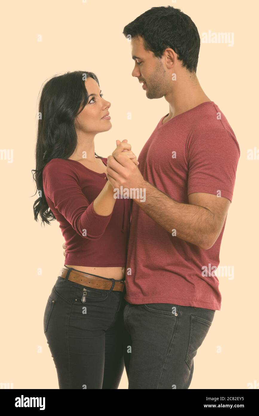 Studio shot della giovane coppia felice sorridere mentre balli e guardando ogni altro Foto Stock