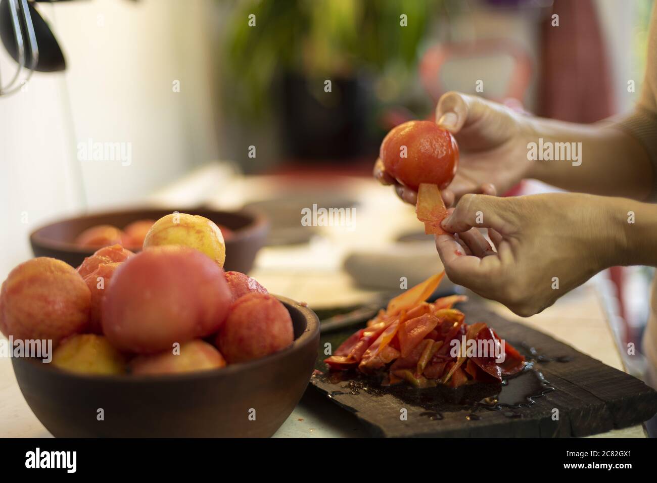 Un colpo di fuoco poco profondo di una femmina che spellano un pomodoro Foto Stock