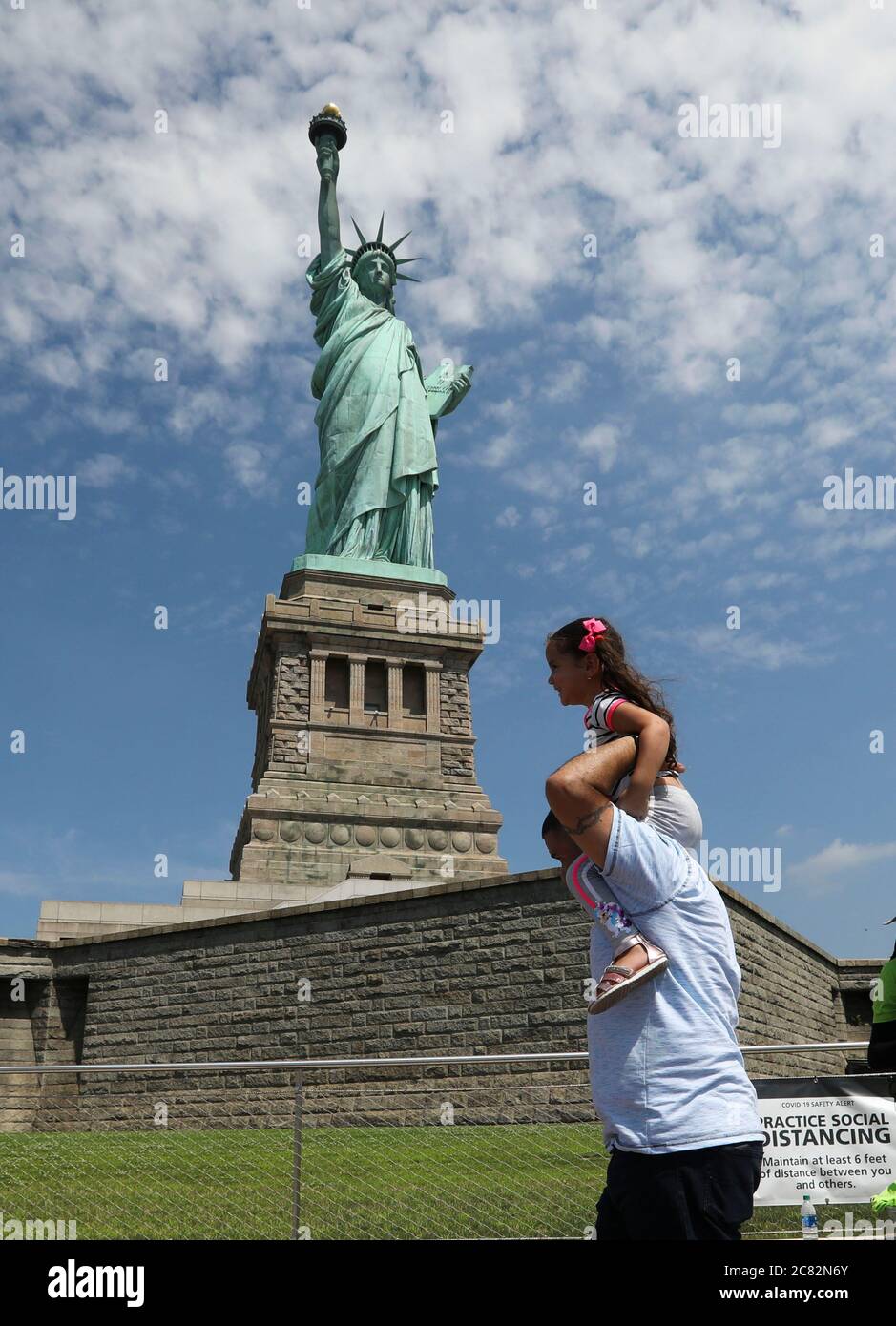 New York, Stati Uniti. 20 luglio 2020. I visitatori visitano Liberty Island a New York, Stati Uniti, il 20 luglio 2020. New York City è entrata nella fase quattro della riapertura lunedì senza riprendere altre attività indoor, in quanto i funzionari locali sono preoccupati per una seconda potenziale ondata di infezioni da coronavirus portate qui da nuovi hotspot in tutto il paese. L'Isola della libertà, dove si trova la Statua della libertà, è diventata aperta lunedì, mentre l'interno della statua e il museo rimangono chiusi al pubblico. Credit: Wang Ying/Xinhua/Alamy Live News Foto Stock