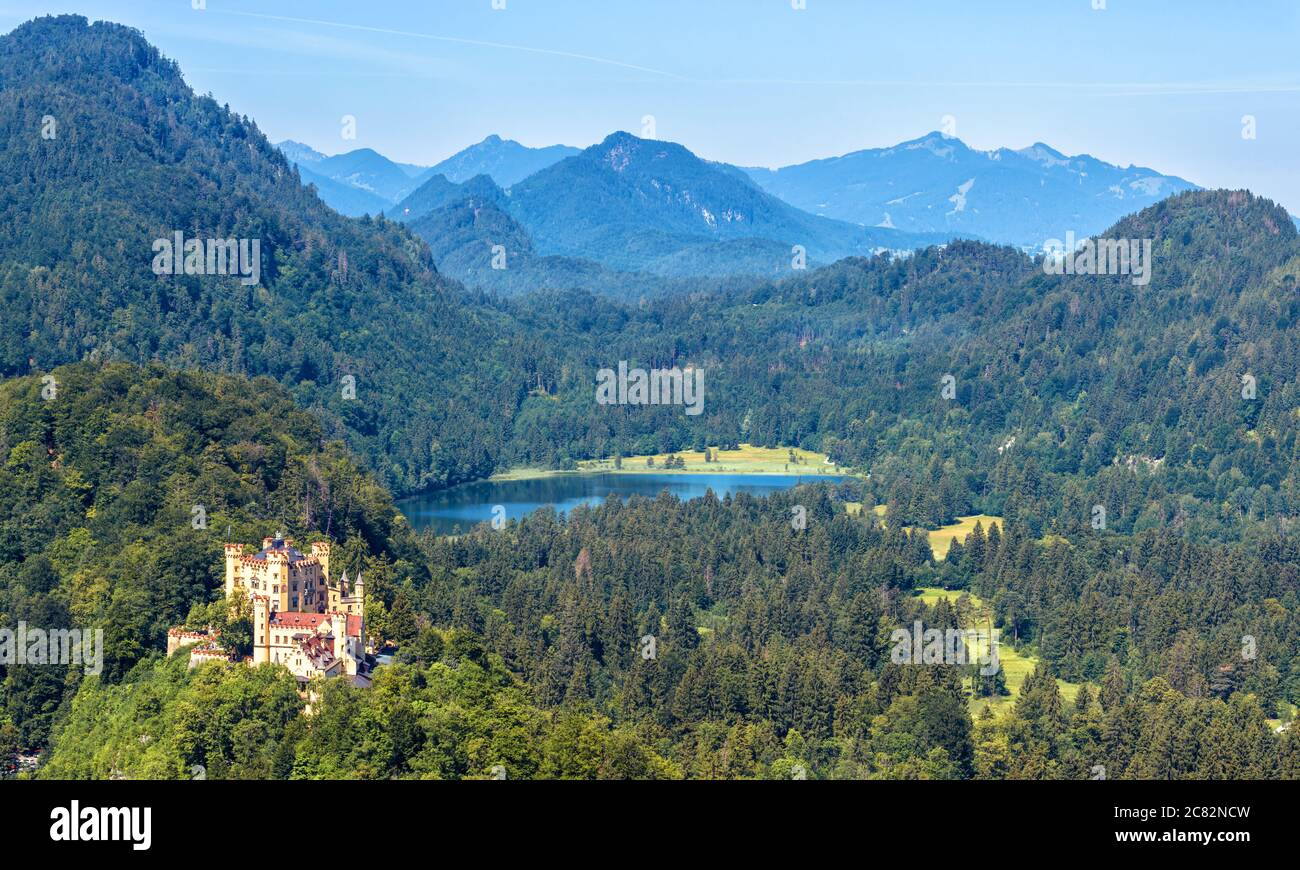 Paesaggio delle Alpi Bavaresi con il Castello di Hohenschwangau, Germania. Vista panoramica aerea del bellissimo castello e del lago Schwansee. Scenario di montagna alpina Foto Stock
