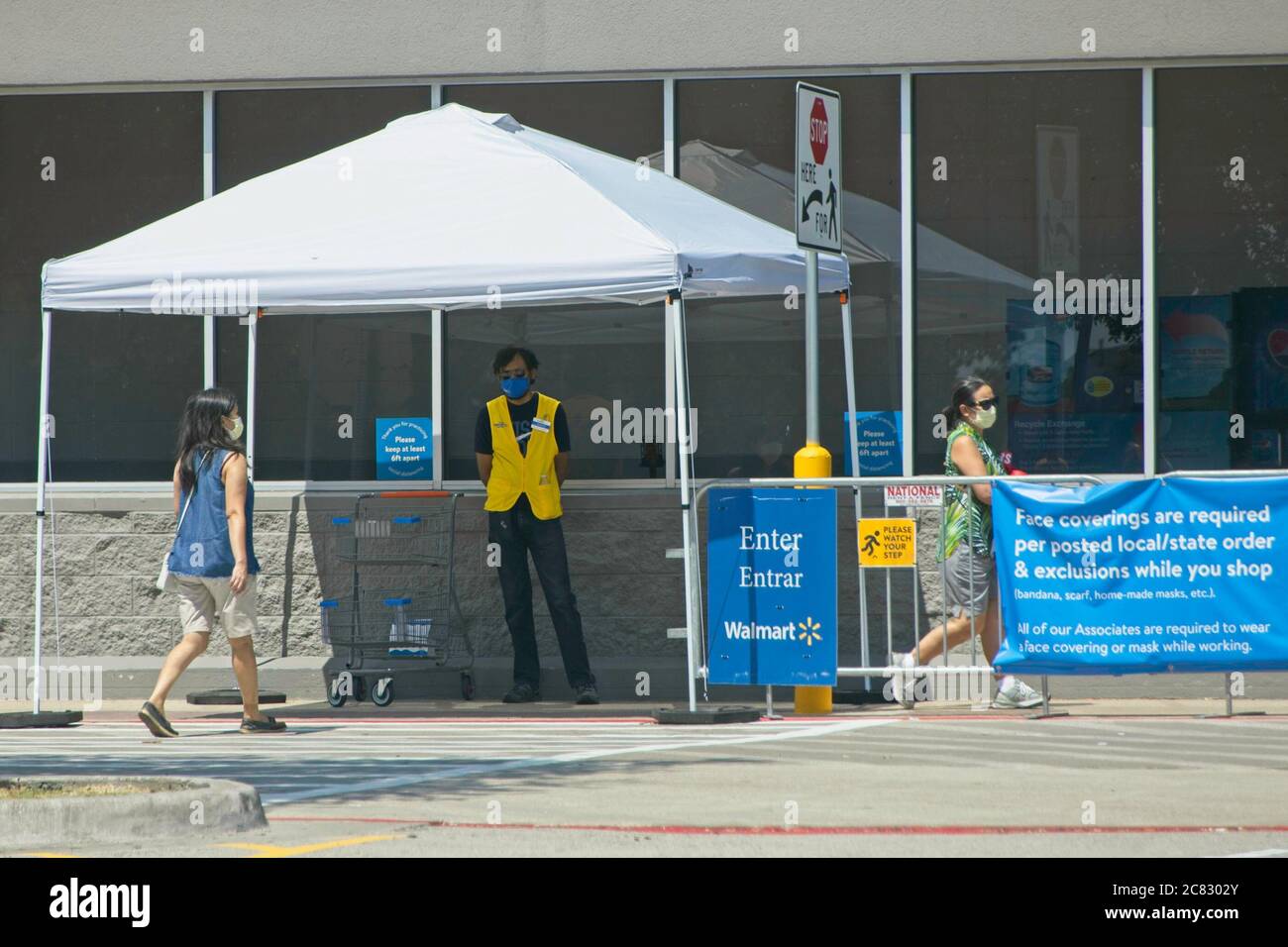 Plano, Stati Uniti. 20 luglio 2020. I clienti che indossano maschere facciali entrano in un negozio Walmart a Plano, Texas, Stati Uniti, il 20 luglio 2020. Il più grande rivenditore al mondo Walmart ha annunciato che gli acquirenti di Walmart e Sam's Club negli Stati Uniti dovranno indossare rivestimenti per il viso a partire da luglio 20. Oltre a lasciare cartelli chiari davanti ai negozi, Walmart ha creato il ruolo di Ambasciatore della Salute e li metterà vicino all'ingresso per ricordare a coloro che non hanno una maschera. Credit: Dan Tian/Xinhua/Alamy Live News Foto Stock