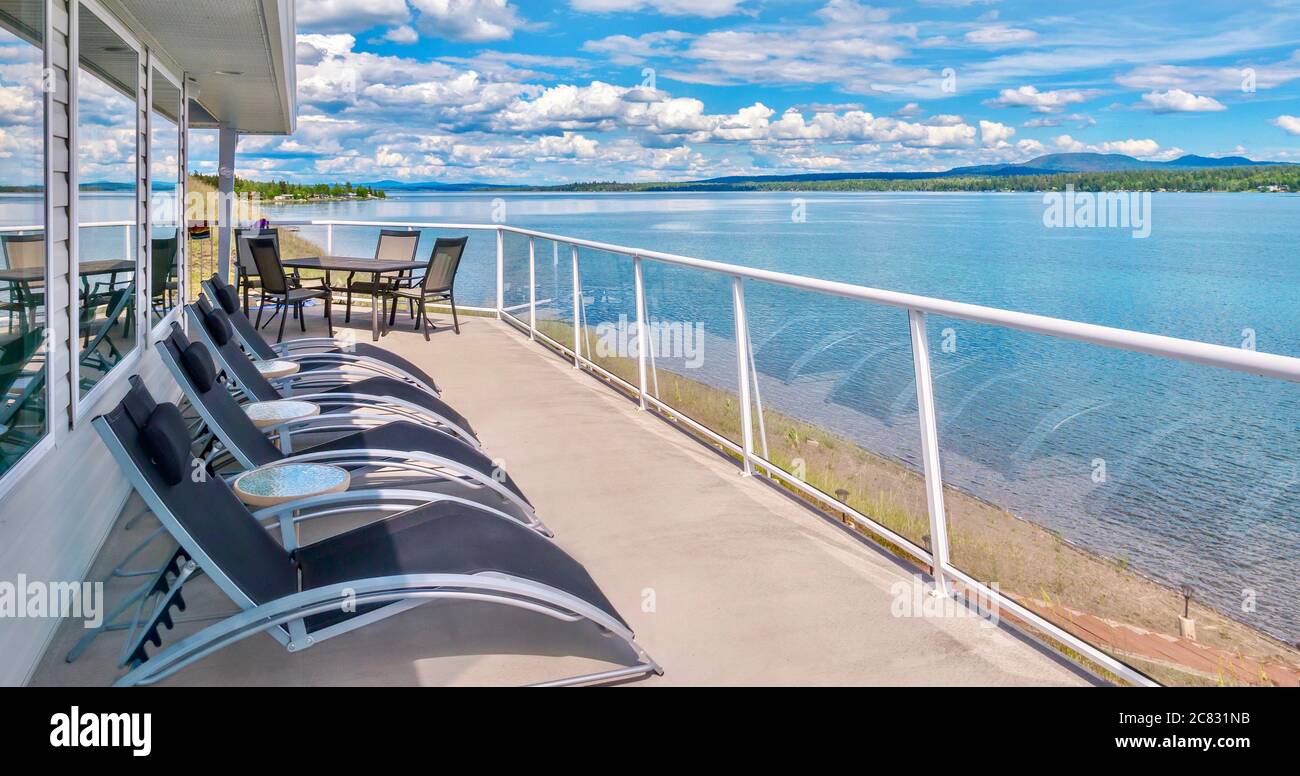 Grande balcone privato con ringhiere in vetro contemporaneo e mobili da terrazza, affacciato su un lago nella British Columbia, Canada. Foto Stock