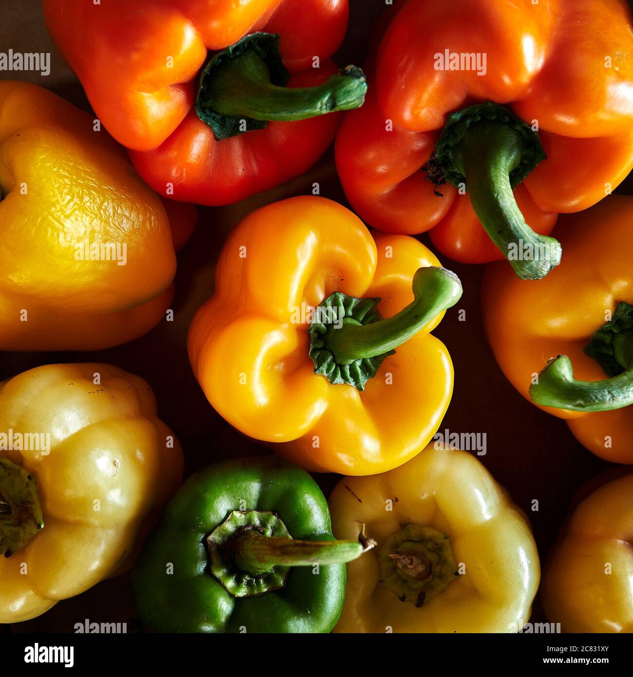 Peperoni gialli, verdi e arancioni in esposizione di verdure fresche, in vendita in azienda o nel mercato agricolo. Foto Stock