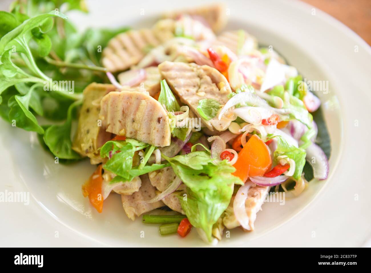 Salsiccia piccante vietnamita con uova salate con tuorlo d'uovo e verdure / insalata di salsiccia di maiale vietnamita su un piatto Foto Stock